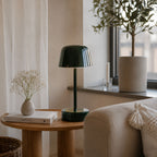 Grön uppladdningsbar bordslampa Domo på träsideboard med modern nordisk inredning och varm belysning.