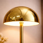 Detaljbild av guld bordslampa i svampdesign med LED ljus och stilren metallfinish