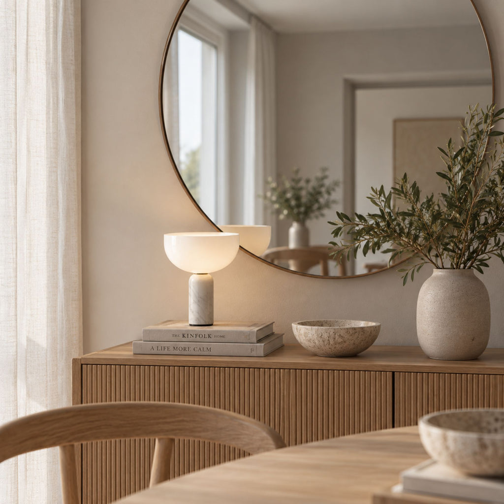Vit marmorbordslampa KINZO på sideboard med spegel och neutral inredning.