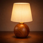 Bordslampa i mörk trä med plisserad lampskärm som ger varm och mysig LED-belysning.