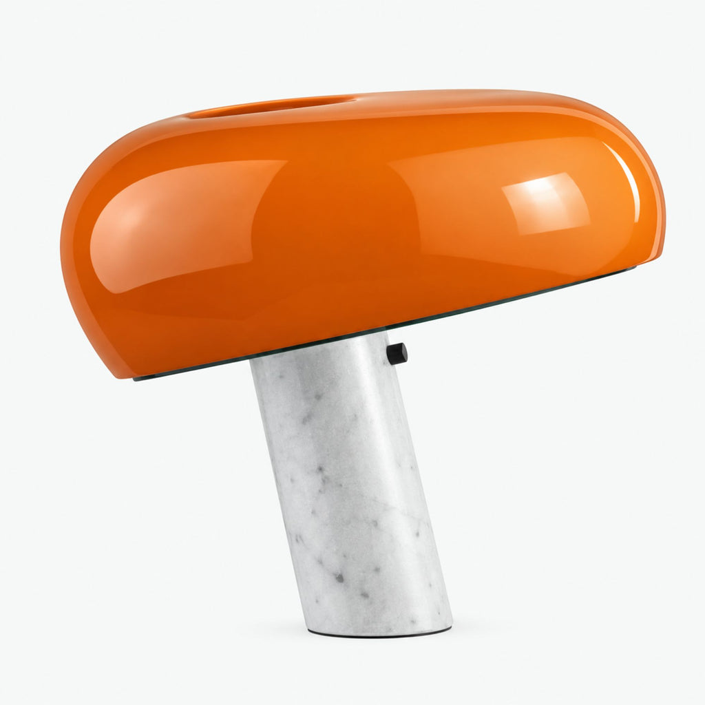 Orange blank bordslampa med vit marmorfot och karaktäristisk rundad lampskärm.