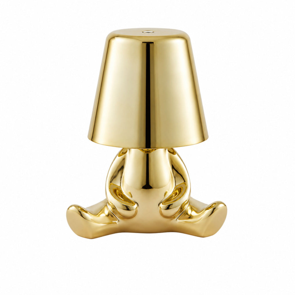 Uppladdningsbar bordslampa Buddy i guld med sittande skulptural design.