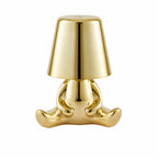 Uppladdningsbar bordslampa Buddy i guld med sittande skulptural design.