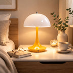 Portabel gul LED bordslampa i svampdesign på sängbord i elegant interiör