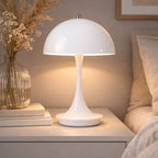 Portabel orange vit bordslampa i svampdesign på träbord i modern interiör