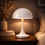 Portabel vit LED bordslampa i svampdesign som lyser varmt på sidobord i modern interiör