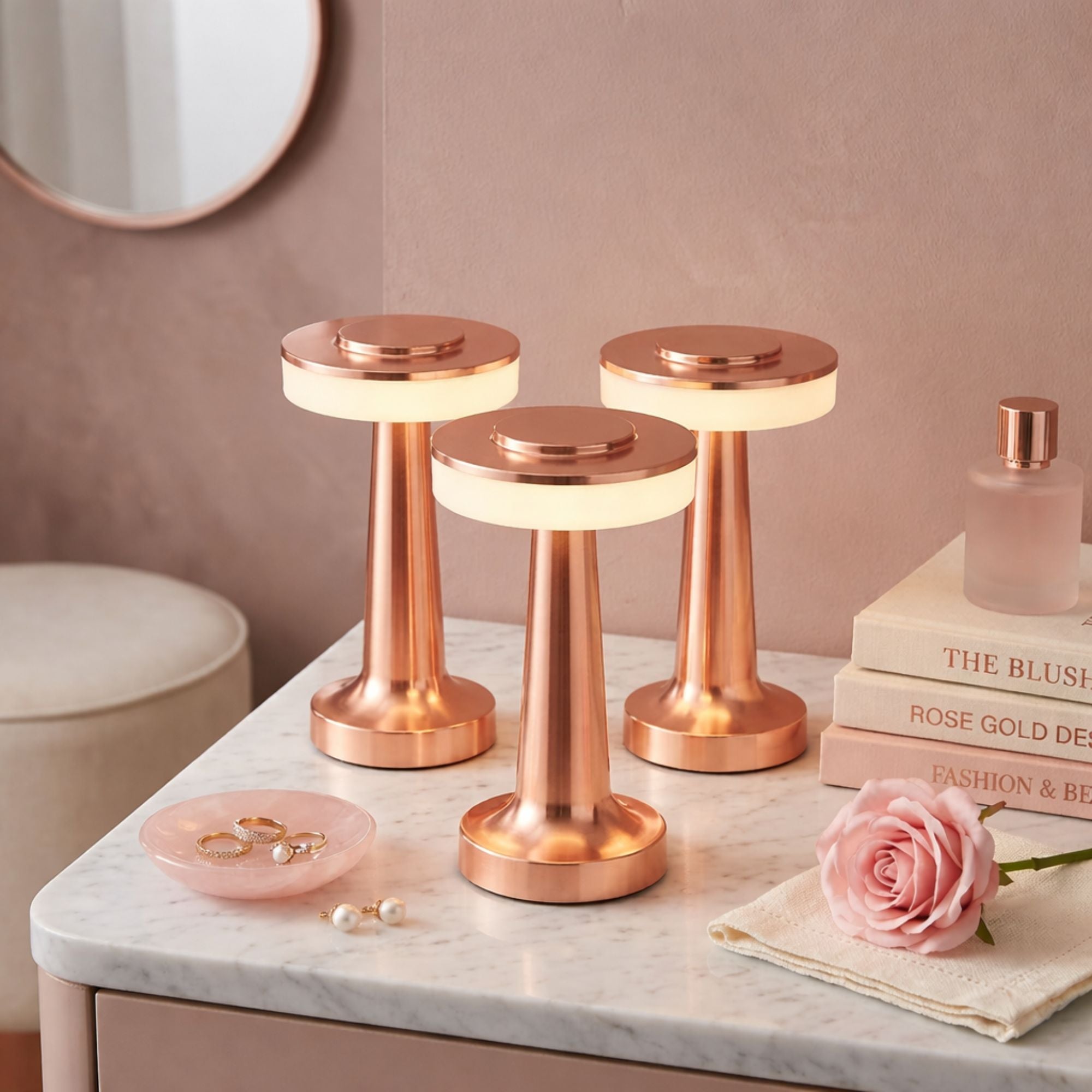 Bordslampa i roséguld med uppladdningsbar LED i set om tre, placerade på marmorbord i lyxig och modern inredning
