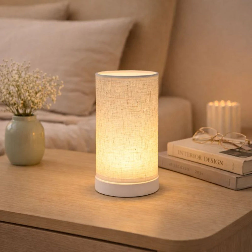 Bordslampa med varm LED-belysning placerad på sängbord som skapar mysig atmosfär i sovrum.