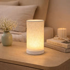Bordslampa med varm LED-belysning placerad på sängbord som skapar mysig atmosfär i sovrum.