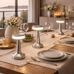 Bordslampa i silver med uppladdningsbar LED placerad på matbord i modern inredning, skapar stilren och behaglig belysning i hemmet