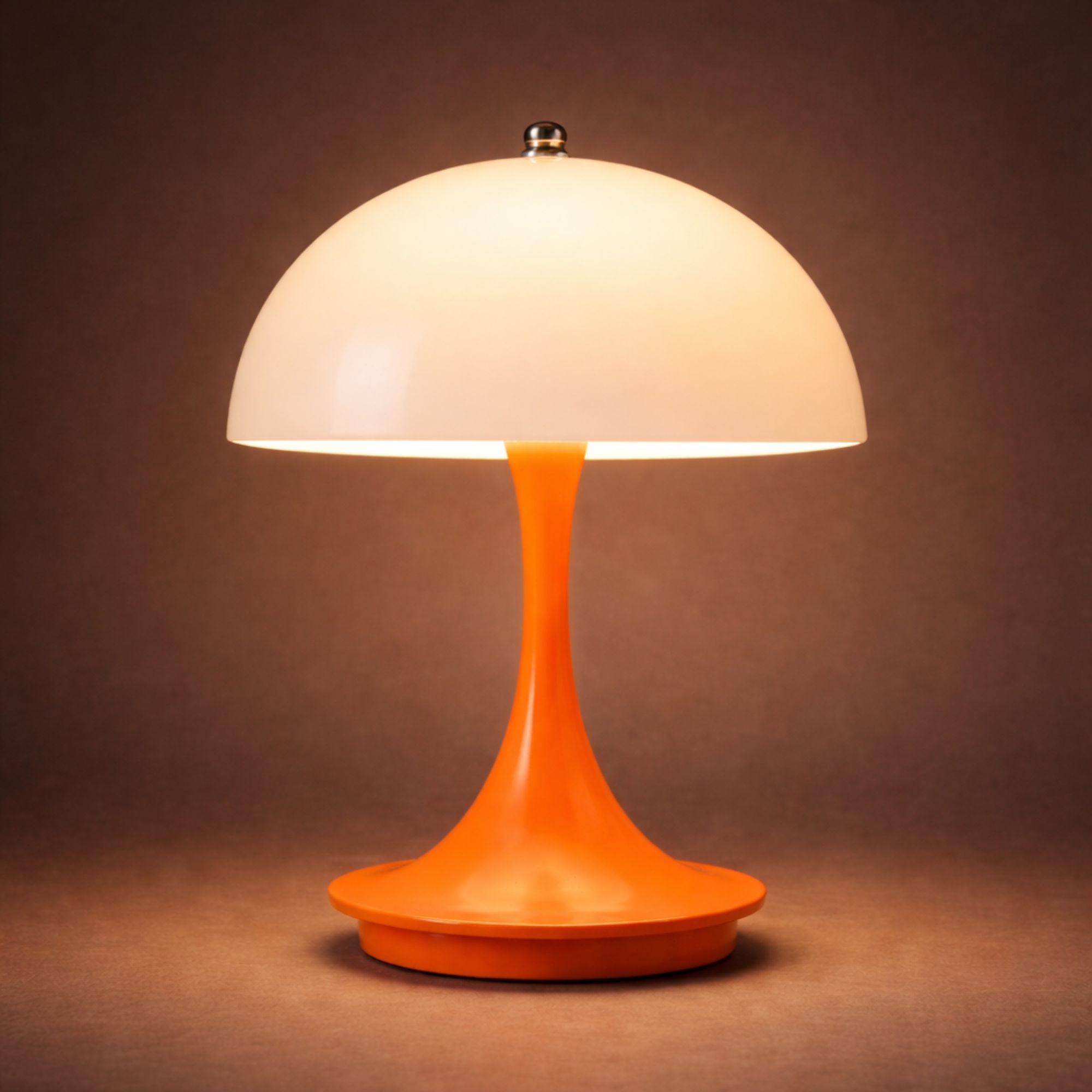 Portabel orange LED bordslampa i svampdesign som lyser med varm belysning mot mörk bakgrund
