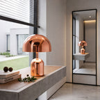 Portabel svamplampa i roséguld LED bordslampa placerad på bänk i modern hall med stilren inredning och naturligt ljus