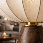 Närbild på bordslampa i trä med textilskärm och mässingsdetalj som visar material och designkvalitet