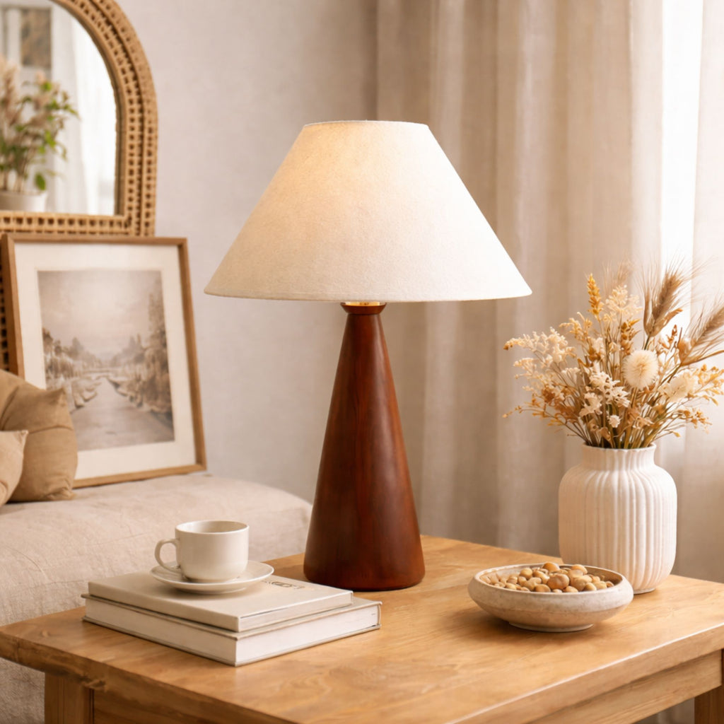 Bordslampa med träfot och beige linneskärm på träbord i vardagsrum med varm och naturlig skandinavisk inredning