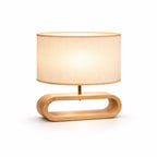 bordslampa i trä med oval bas och tygskärm i modern design på vit bakgrund