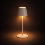 Vit uppladdningsbar LED bordslampa med touchkontroll och steglös dimning som lyser med varmt stämningsljus i mörk studio