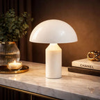 Vit modern bordslampa i svampdesign placerad på marmorbord med varm belysning – perfekt som stämningsbelysning i sovrum eller vardagsrum