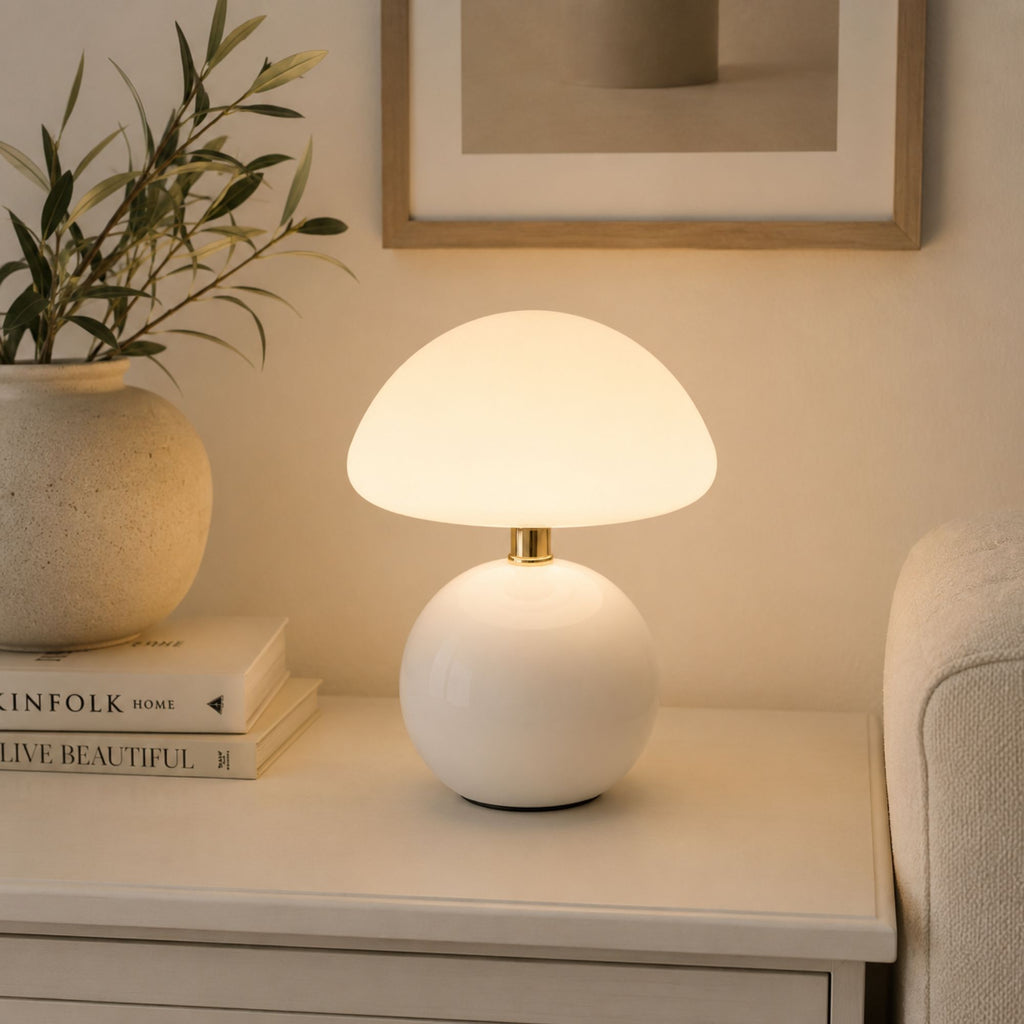 Vit bordslampa placerad på sideboard i modernt skandinaviskt vardagsrum.