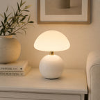 Vit bordslampa placerad på sideboard i modernt skandinaviskt vardagsrum.