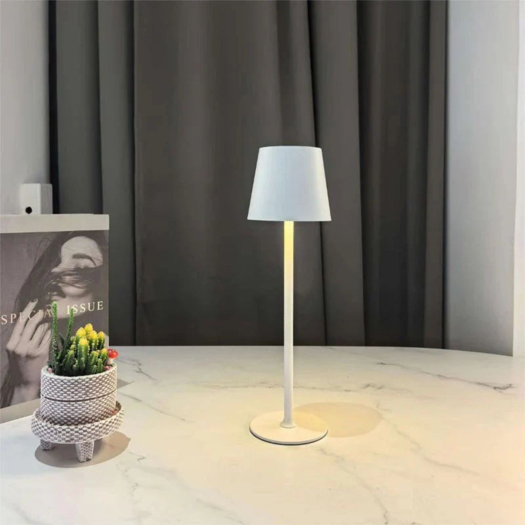 Vit uppladdningsbar LED bordslampa på kaffebord i modern skandinavisk inredning med varmt stämningsljus