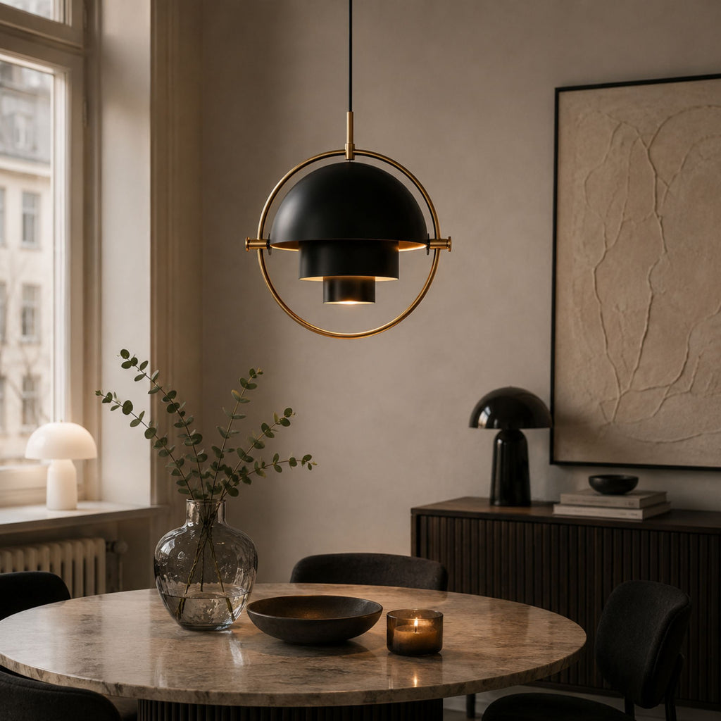 Svart taklampa med mässingsdetaljer i ljust skandinaviskt köksrum med modern inredning.