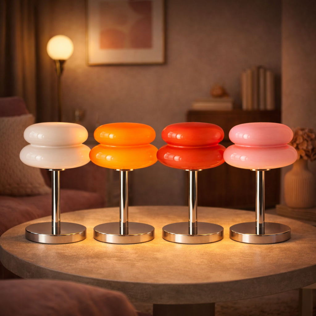 Retro bordslampa i glas med kromfot i färgerna vit, orange, röd och rosa på bord i mysigt vardagsrum