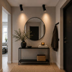 Svarta LED-spotlights i modern hall med rund spegel och stilren inredning.