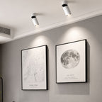 Vita LED-spotlights som belyser tavlor i ett modernt skandinaviskt vardagsrum.