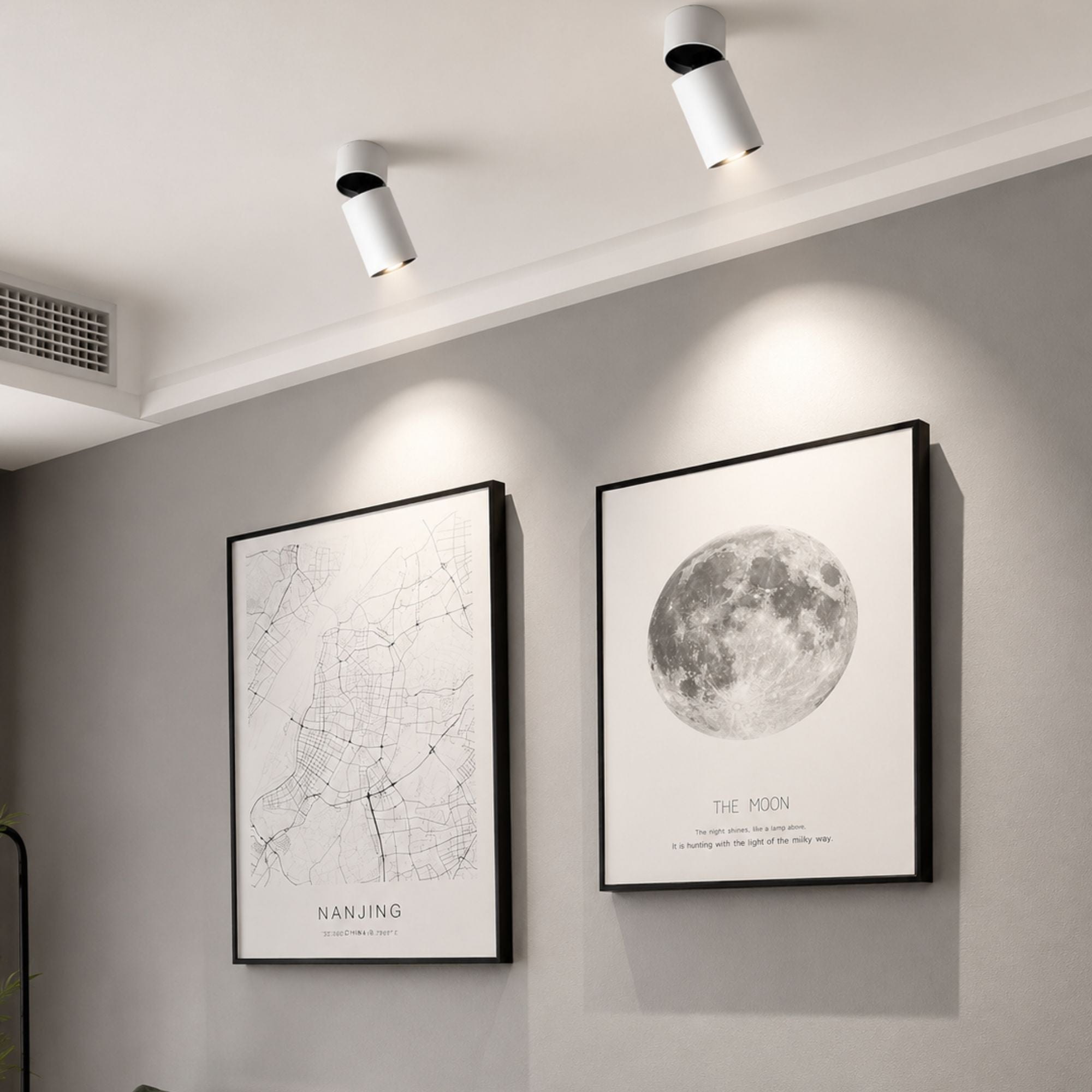 Vita LED-spotlights som belyser tavlor i ett modernt skandinaviskt vardagsrum.
