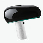 Svart blank bordslampa med vit marmorfot och modern rundad lampskärm.