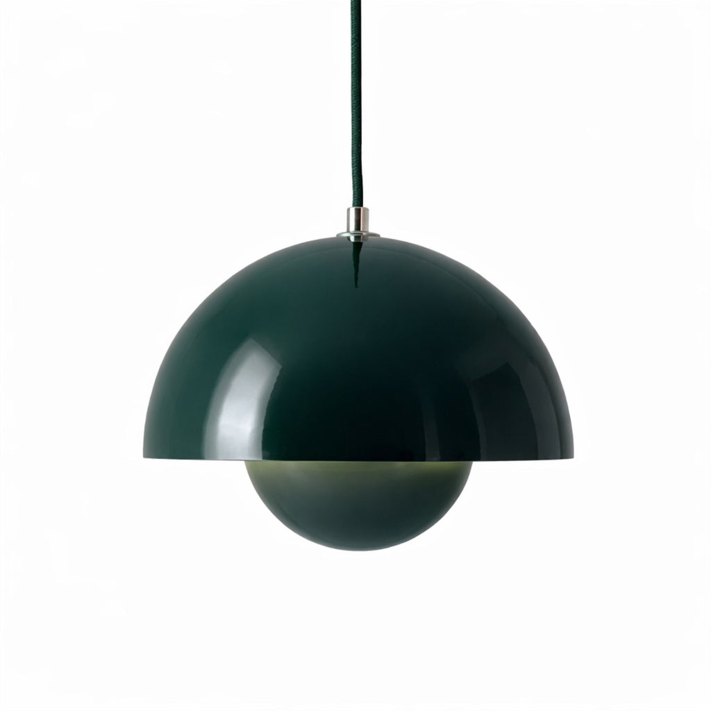 Grön pendellampa med rund metallskärm i modern skandinavisk design.