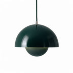 Grön pendellampa med rund metallskärm i modern skandinavisk design.