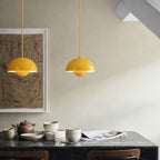 Taklampa gul rund retro pendellampa över matbord i skandinavisk design.