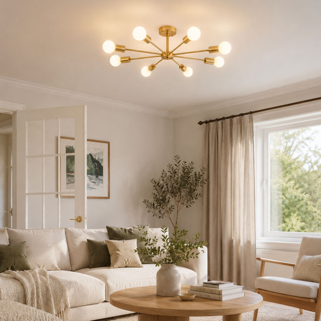 Taklampa i mässing med 8 armar och glaskulor i modern design över matbord i ljust matrum.