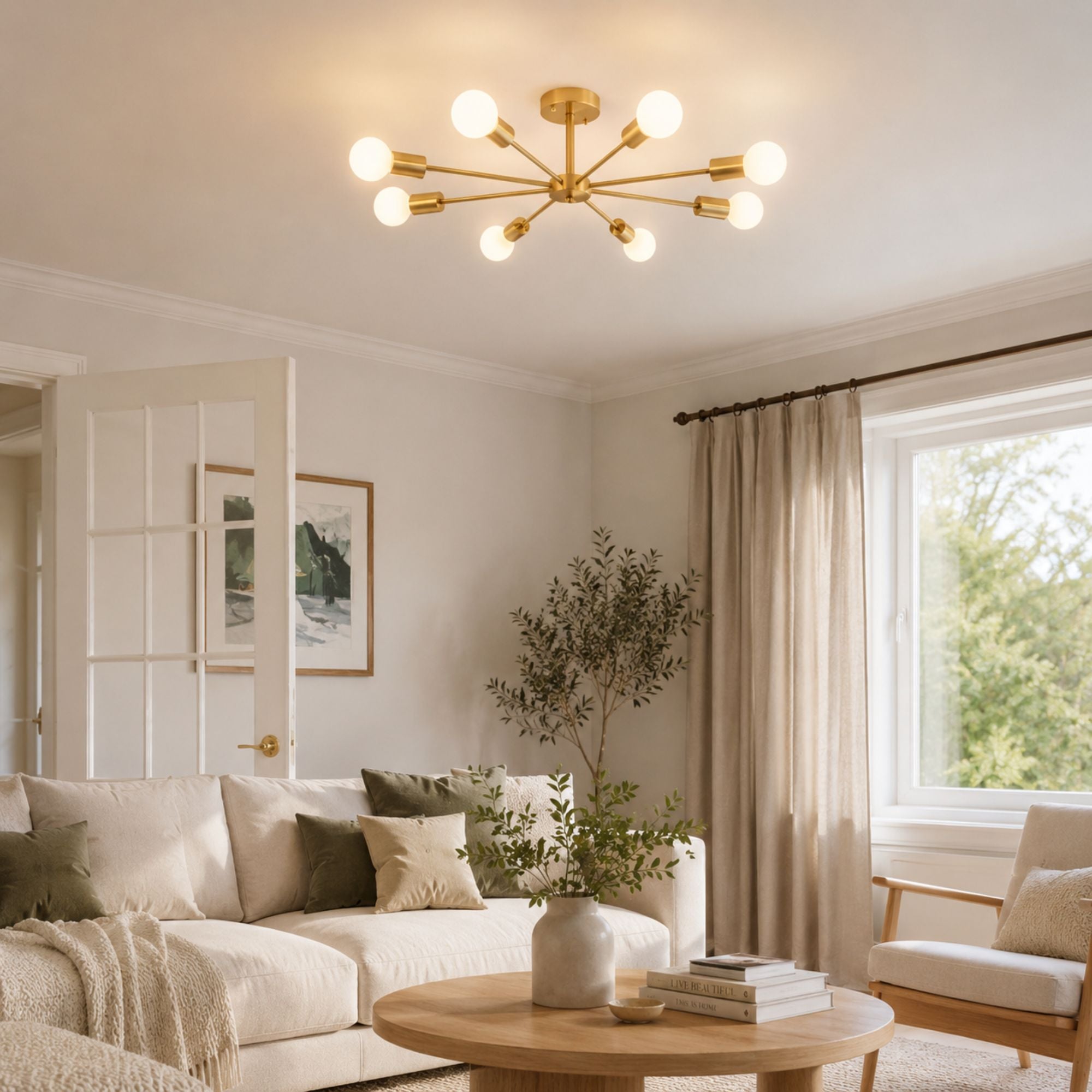 Taklampa i mässing med 8 armar och glaskulor i modern design över matbord i ljust matrum.