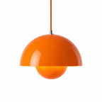 Orange pendellampa med rund metallskärm och sfärisk glaskupa i modern retroinspirerad skandinavisk design.