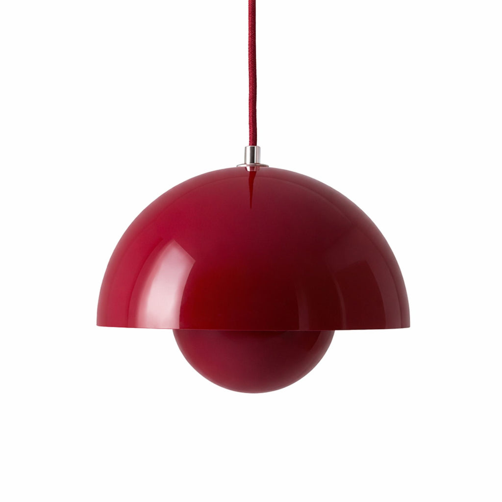Röd pendellampa med rund metallskärm i modern skandinavisk design.
