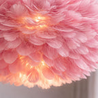 Taklampa rosa fjäderlampa modern pendellampa i fjädrar närbild med varmt ljus.
