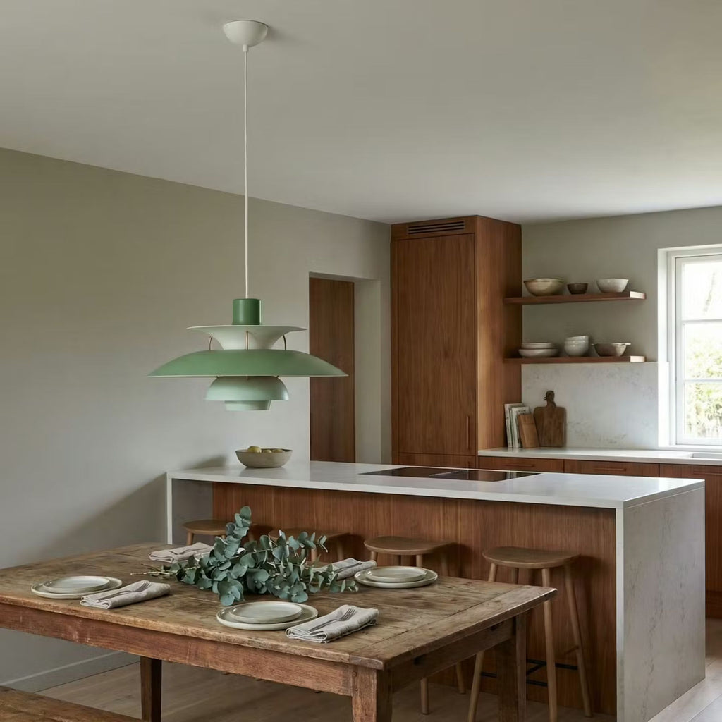 Taklampa pendellampa i grön metall med skandinavisk design över rustikt matbord i kök.