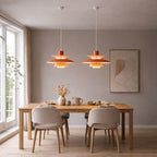 Taklampa pendellampa i orange metall med skandinavisk design över matbord i nordisk inredning.