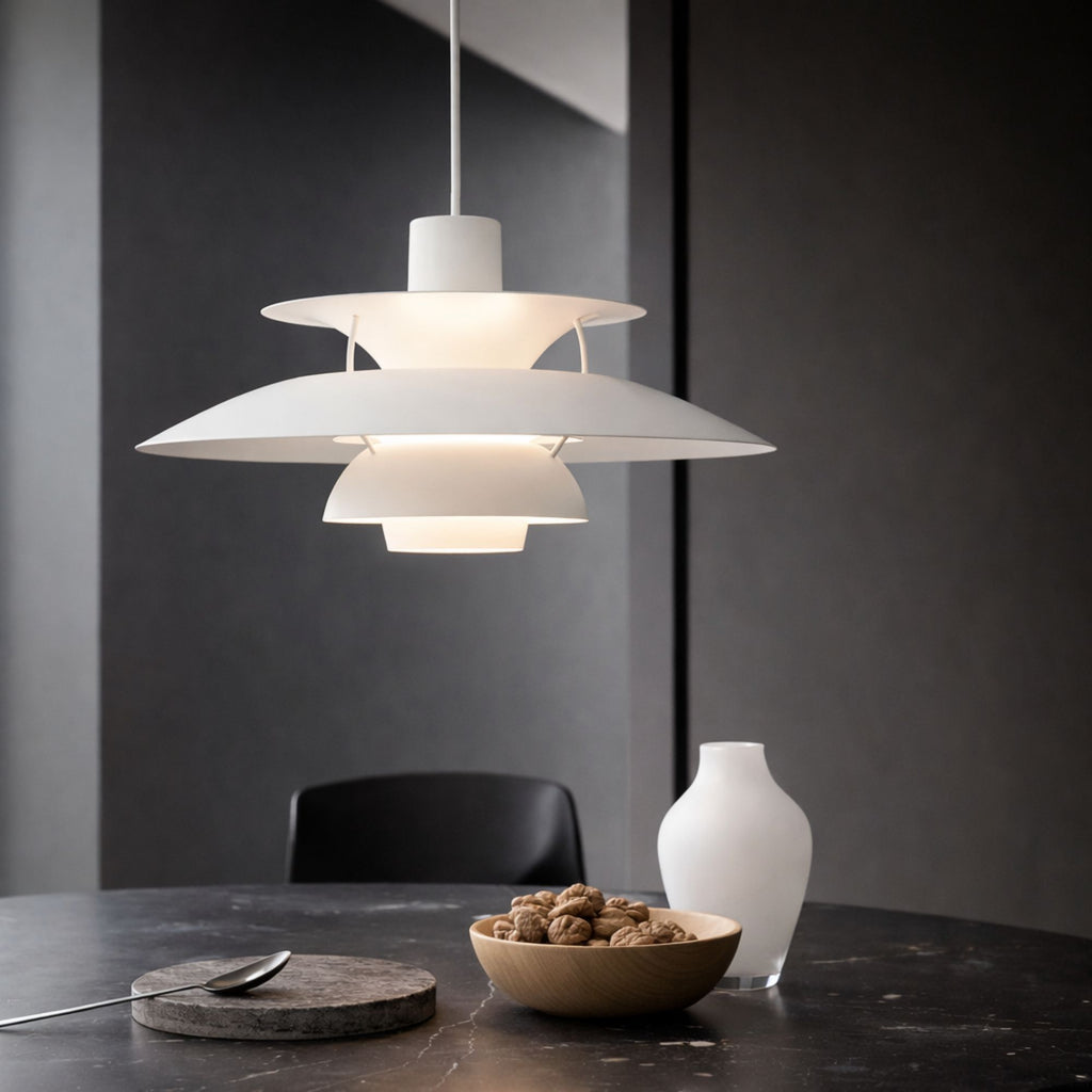 Taklampa pendellampa i metall med skandinavisk flerskärmsdesign som sprider varmt ljus över matbord på kvällen i köket.