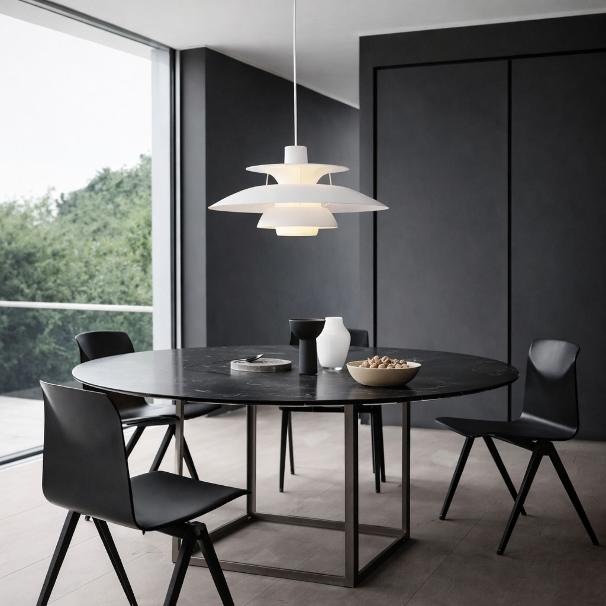 Pendellampa i vit metall med skandinavisk design som ger varm stämningsbelysning över matbord.