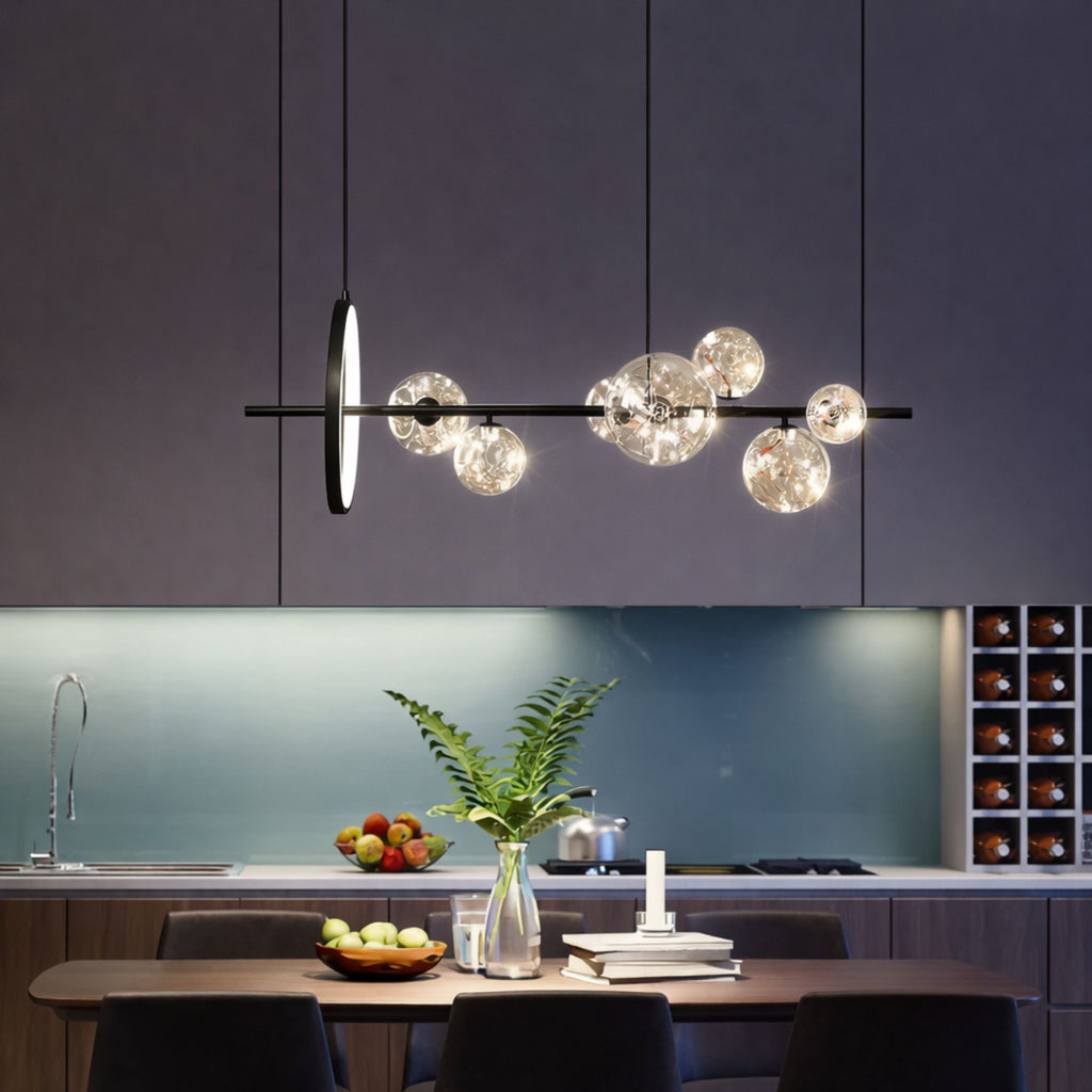 Modern svart taklampa med glaskupor ovanför matbord i kök som ger stilren och varm belysning.
