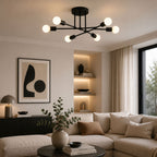 Taklampa i modern svart plafonddesign med 6 globlampor som skapar varm och exklusiv belysning i ett stilrent vardagsrum med elegant och modern heminredning.