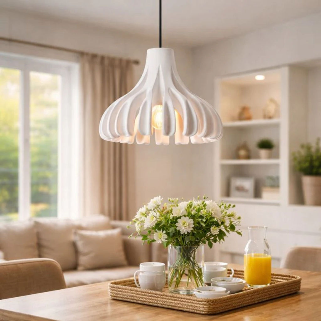 Modern pendellampa över matplats i vardagsrum som ger varm och stilren belysning.