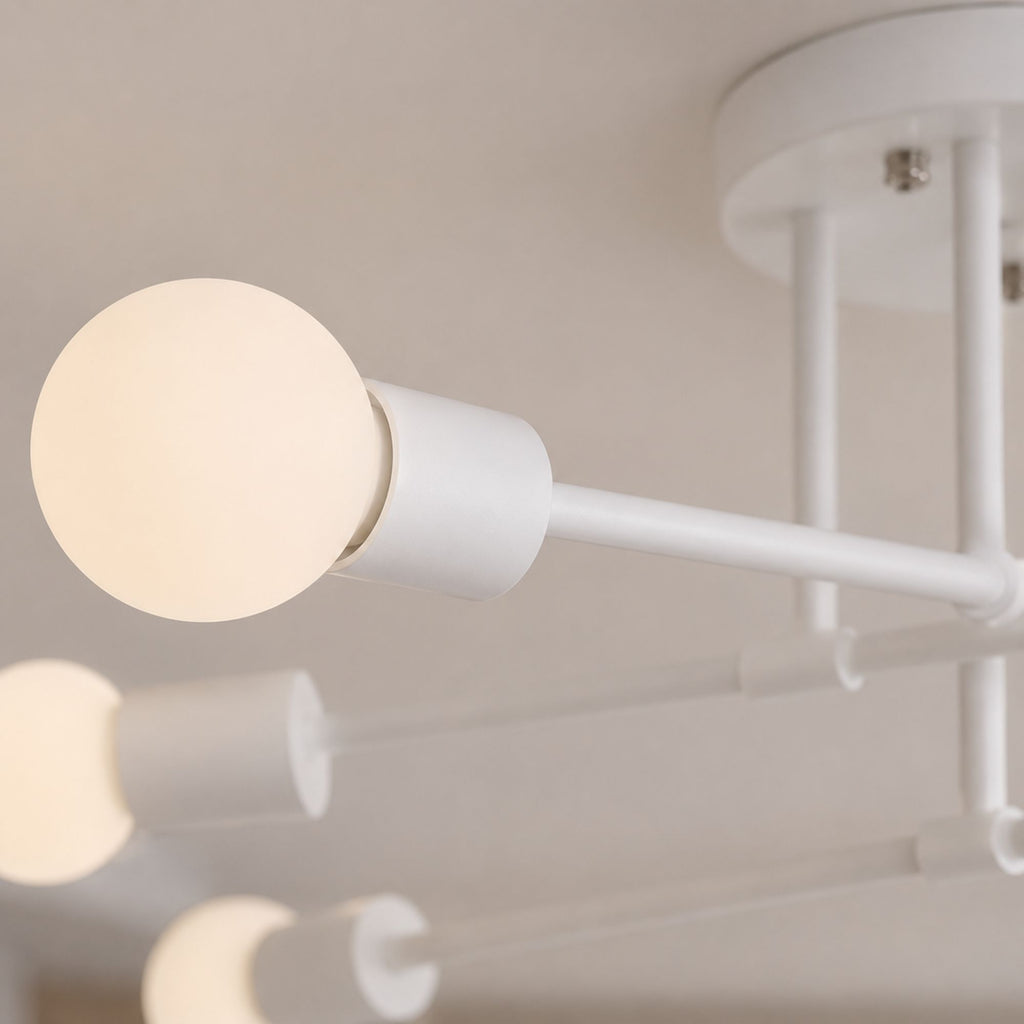 Taklampa detaljbild i close-up som visar vitlackerad metall och vit glob i frostat glas med modern minimalistisk design och elegant mjuk belysning.