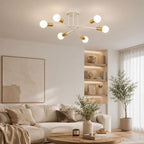 Taklampa i modern vit plafonddesign med 6 globlampor och eleganta guldfärgade detaljer som skapar varm och exklusiv belysning i ett stilrent vardagsrum med harmonisk heminredning.