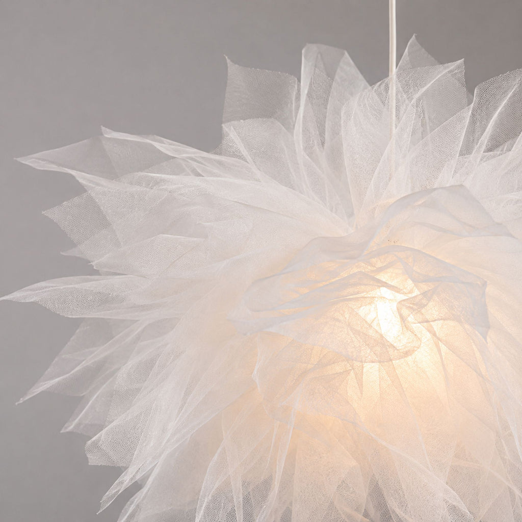 Närbild av vit blomformad taklampa i mesh som visar de luftiga lagren och den eleganta texturen
