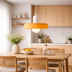 taklampa i vit och orange design hängande över matbord i stilrent skandinaviskt kök med varm och modern känsla