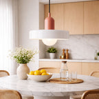 taklampa i vit och rosa modern design hängande över marmorbord i stilrent skandinaviskt kök med mjuk belysning